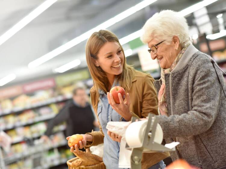 Woman helping elderly lady shop